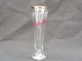 a clear glass with a gold rim sitting on a gray surface