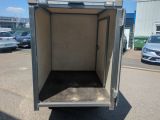 an image of a small enclosed trailer in a parking lot