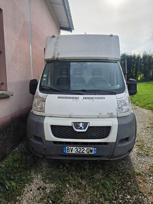une camionnette blanche garée devant un immeuble rose