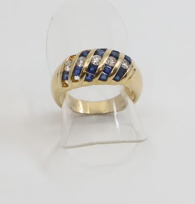 gros plan d'une bague en or avec saphirs et diamants