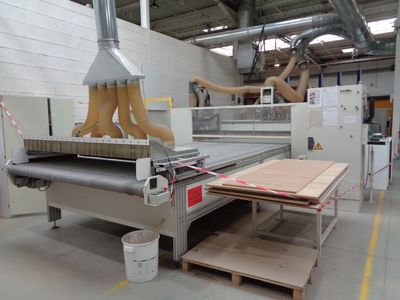a machine that is cutting wood in a factory