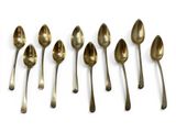 six spoons are lined up in a row on a white surface