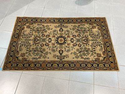un tapis posé à même le sol dans une pièce aux carreaux blancs