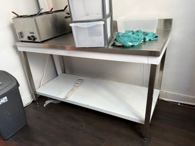 une table en métal sur laquelle se trouve une poubelle