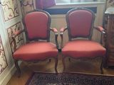 two red chairs in a room with a rug on the floor