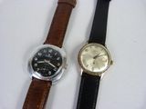 deux montres assises l'une à côté de l'autre sur une surface blanche