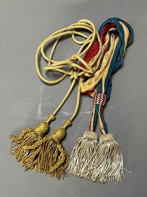 two tassels are tied together on a gray surface