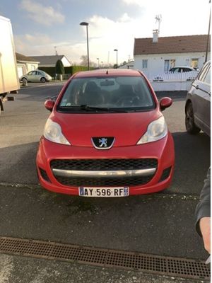 une voiture rouge garée dans un parking