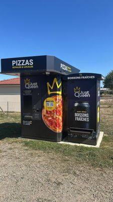 a black box with a pizza on it sitting in the middle of a field