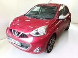 La voiture rouge est garée sur le sol blanc de la pièce.