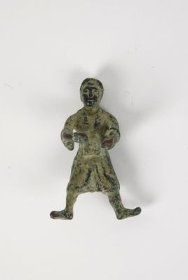 une vieille figurine en bronze représentant un homme coiffé d'un chapeau