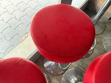 three red stools that are sitting on a table