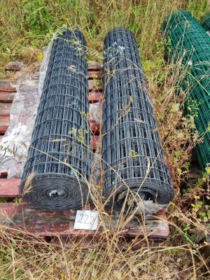 deux rouleaux de fil métallique posés sur une palette dans l'herbe