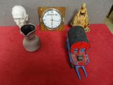 une statue représentant un homme assis à côté d'une horloge et une statue représentant un homme