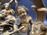 une statue représentant un garçon et une fille assis sur un banc