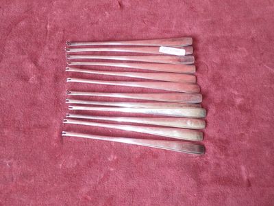 six silverware spoons on a pink cloth with a red background