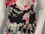 a black and white floral print dress with pink flowers on a mannequin