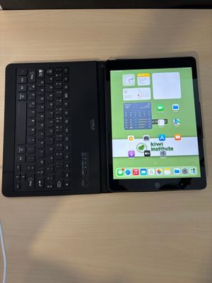un ordinateur portable et une tablette posés sur un bureau, avec un clavier