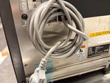 wires are plugged into the back of a microwave on a table
