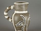 a brown and white vase with a bird painted on it