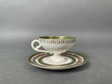 a cup and saucer sitting on a saucer
