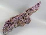 a small piece of purple stone on a white surface