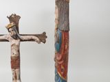 two figurines of jesus on a cross and a crucifix