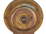 underside view of a brass plated clock on a white background