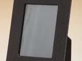 photo d'un cadre noir posé sur une table blanche, sur fond jaune