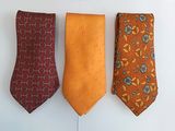 three different colored ties hanging on a wall next to each other