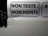 a sign that says non teste / a non monte on a desk