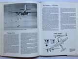 an open book with a picture of a plane flying in the sky