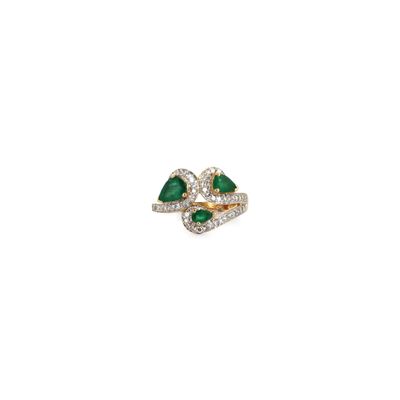 a close up of a diamond and emerald ring on a white background