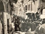 photographie en noir et blanc représentant une foule de personnes marchant dans une rue