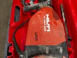 une boîte à outils rouge contenant une perceuse et un cordon d'alimentation