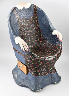 une statue représentant une femme assise sur une chaise
