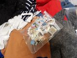 a pile of clothes that is sitting on a bed