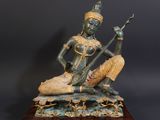 bronze statue of a woman playing a musical instrument on a wooden base