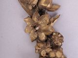 a gold colored necklace with flowers and leaves on it