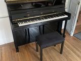 a piano in the corner of a room with wood floors