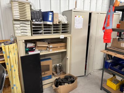 a room with a refrigerator, shelves, and other items in it