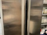 a stainless steel refrigerator in a kitchen next to a counter