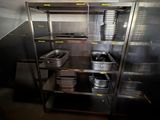 une cuisine équipée d'armoires en inox et de casseroles et poêles