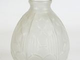 a white glass vase with a design on it