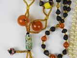 many different beads and necklaces that are on a table