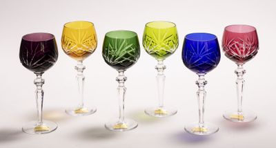 cinq verres à vin alignés sur une surface blanche