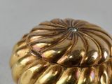 an image of a gold plated object on a white surface