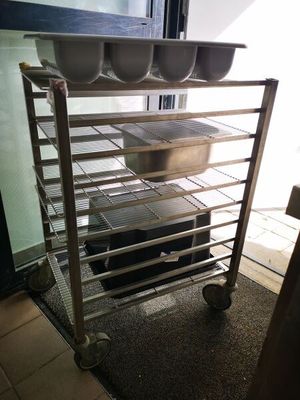 une photo d'une cuisine avec des casseroles et des poêles posées sur une étagère
