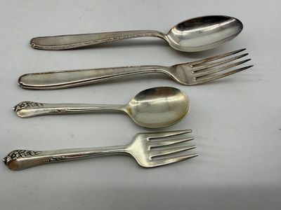 four forks and two spoons on a white surface