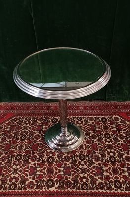 a small round table with a glass top on a rug